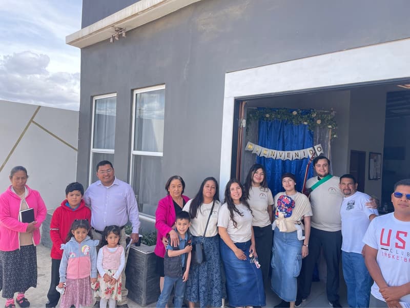 Church members and children at the entrance of the Ensenada church, with a welcome garland in the doorway.