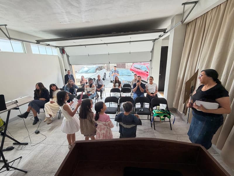 Children gathered at the front for the children's message at the Tijuana church, with adults seated behind them.
